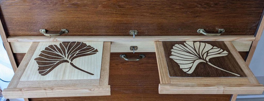 Aktenauszüge mit Ginkoblättern aus dem Lasercutter für das Möbel aus dem Amt